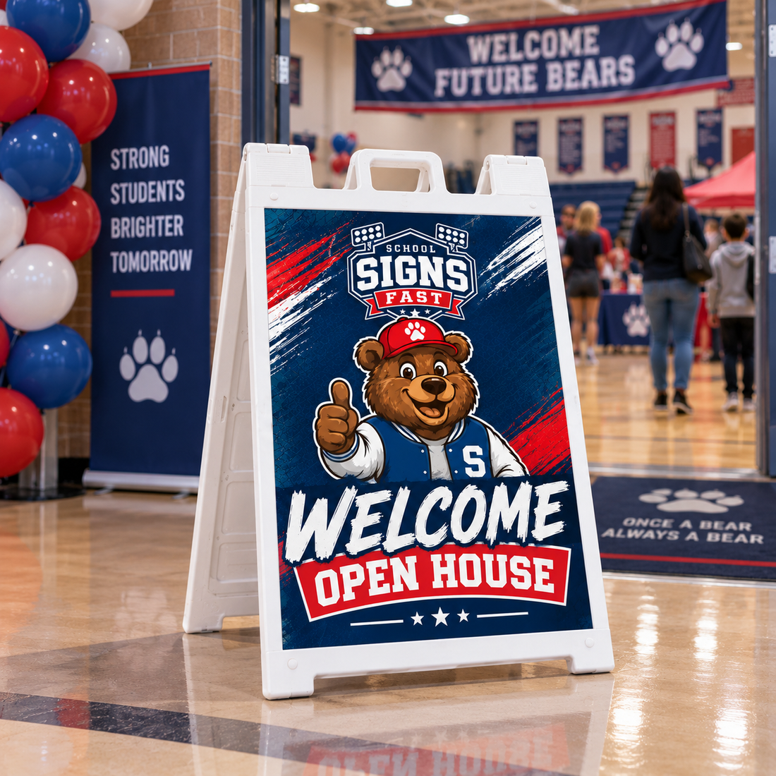 White A-frame sign reading Welcome Open House in a school lobby with red and blue balloons
